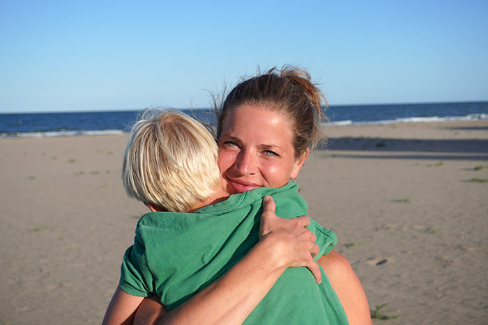 kristin holtkamp Sohn und Mutter in Kontakt am Strand. Mutter umarmt Sohn. Co-Regulation findet statt.